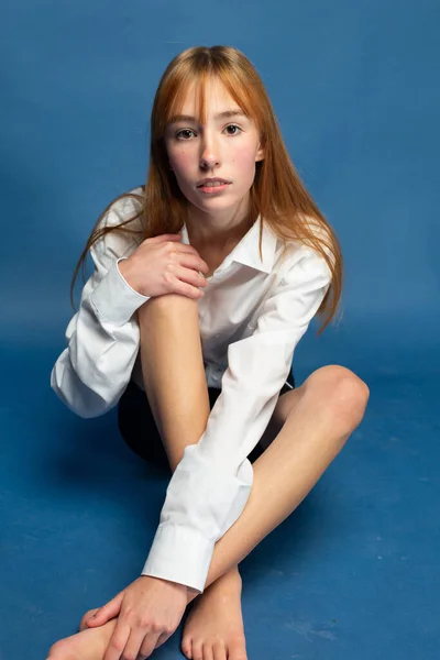 Menina Sentada Com Cabelo Vermelho Pele Branca Isolada Azul Aparência — Fotografia de Stock