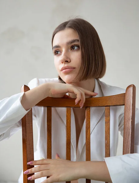 白いビジネススーツで椅子に座って座っているボブカットと白いヨーロッパの女性の肖像 — ストック写真