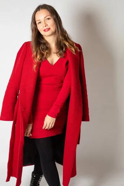 迷人的年轻的欧洲女人 穿着红色的衣服 与浅灰隔离 — 图库照片