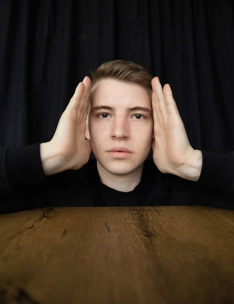 Портрет Молодого Блондина Изолированного Черных Руках Возле Лица Над Столом — стоковое фото