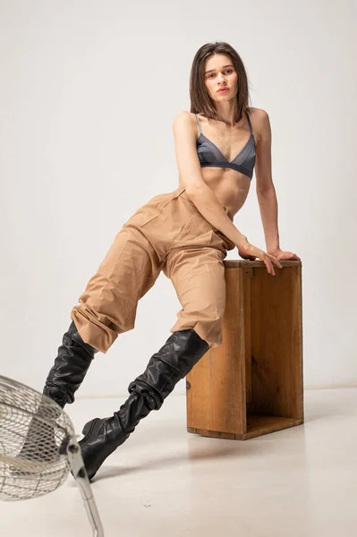 Młoda Szczupła Kobieta Siedzi Drewnianej Skrzyni Studio Beżowych Odcieniach — Zdjęcie stockowe