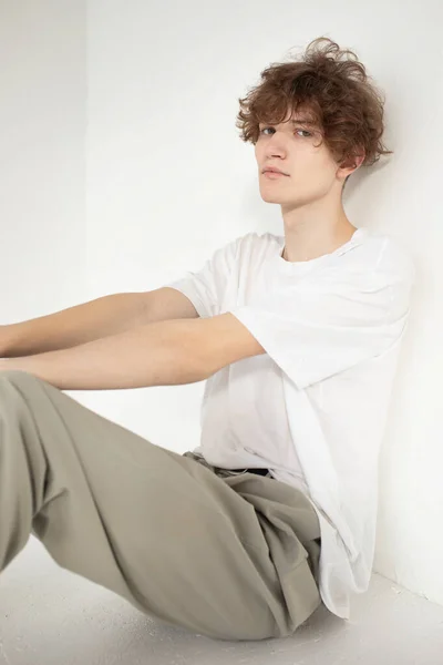 Atraente Jovem Europeu Isolado Bege Sentado Chão Camisa Branca — Fotografia de Stock
