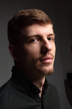 Siyah sakallı ve bıyıklı genç Avrupalı bir adamın gölgesinde portre.