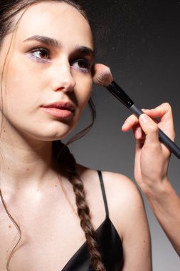 Koyu gri üzerinde kahverengi gözlü iki örgülü genç Avrupalı kadın makyajı portresi