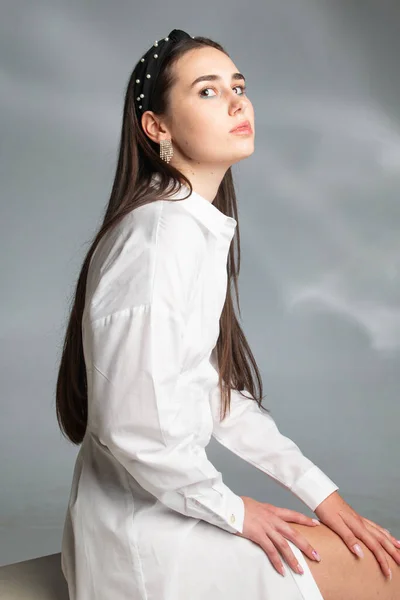 Jovem Sentada Com Cabelo Escuro Blusa Branca Manga Comprida Isolada — Fotografia de Stock