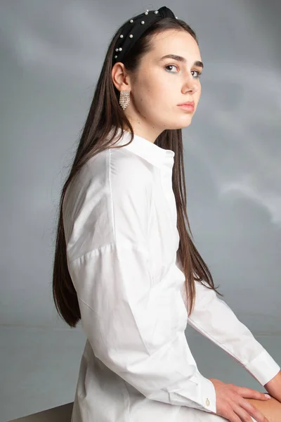 穿着白色长袖衬衫的年轻女子 深色头发 与灰色隔离 — 图库照片