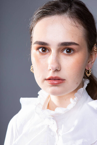 Белая молодая европейская женщина с темно-коричневыми глазами с собранным портретом крупным планом
