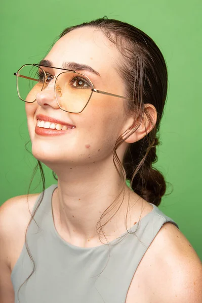 Portret Uśmiechniętej Młodej Kobiety Ciemnymi Włosami Okularach Odizolowanej Zielono — Zdjęcie stockowe