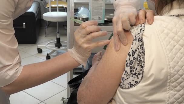 Close-up van de arm van een onherkenbaar volwassene die coronavirusvaccin krijgt Rechtenvrije Stockvideo