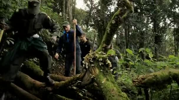 2018年8月 ウガンダのブウィンディ原生林にある国立公園で山ゴリラを探す太いジャングルパスでガイドとレンジャーを追いかけるカメラ — ストック動画
