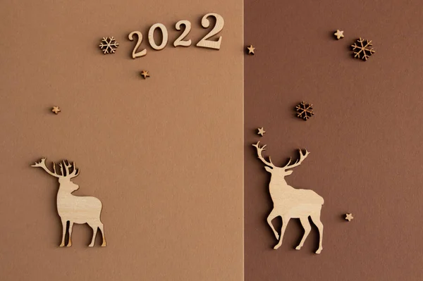 2022, kahverengi ve bej arkaplanlı şık Noel kompozisyonu, ahşap heykelcikler, fotokopi alanı. Yüksek kalite fotoğraf