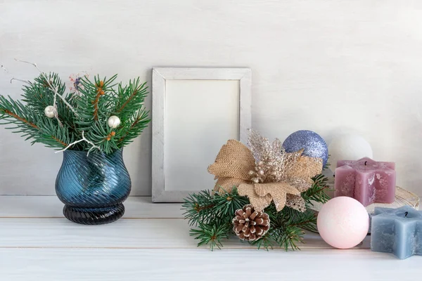 Weihnachtsdekoration, weiße Rahmen-Attrappe mit Tannenstrauß, Kerze und Weihnachtskugeln auf weißem Tisch, Kopierraum — Stockfoto