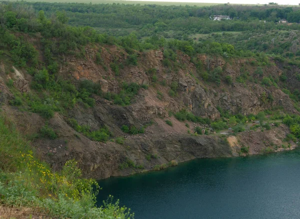Kayalık uçurum ve göl, koyu mavi su, taş ocağı gölleri. 