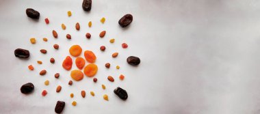 Güneşli, hurma, kurutulmuş kayısı, fındık, badem, şekerli meyve ve kuru üzüm şeklinde yaratıcı yiyecekler. Vegan doğal antioksidan yiyecekler, sağlıklı yiyecekler. Ekstra geniş afiş. Boşluğu kopyala. 