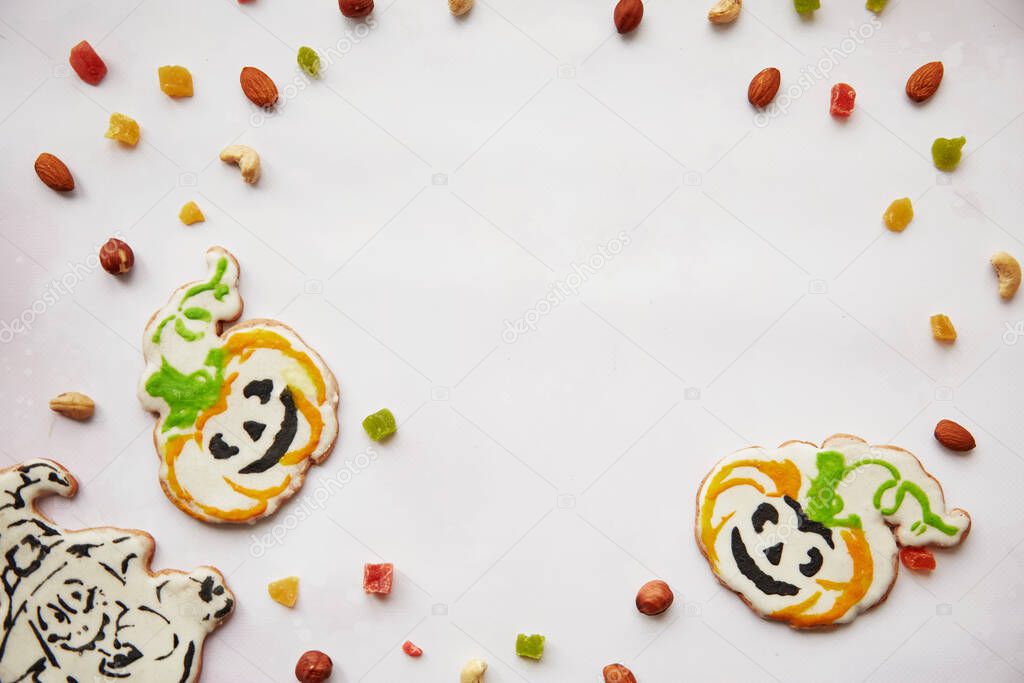 Halloween creative treats: homemade pumpkin cookies with dried fruits, candied fruits, cashews, hazelnuts. Trick or treat concept. Autumn cozy home concept with healthy snacks. Copy space.