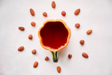 Balkabağı şeklinde çay ile nefis badem ve fındık. Vegan doğal sağlıklı gıda yeme konsepti. Sıcak sonbahar ev atıştırmalıkları.