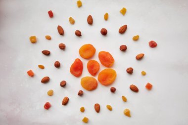 Kurutulmuş kayısı, fındık, badem, şekerli meyve ve kuru üzümlü güneş şeklinde yaratıcı yiyecekler. Vegan doğal antioksidan yiyecekler, sağlıklı beslenme konsepti. Vejetaryen yemeği, sağlıklı beslenme konsepti