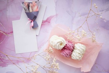 Pembe ve beyaz jigolo ve kuru çiçek desenli marşmelov. Kartı düzenle. Kadınsı arka plan, şablon. Sıcak kış hafta sonları. Ev yapımı tatlılar. Yüksek kalite fotoğraf