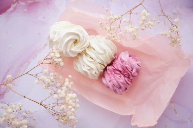 Kadınsı arkaplan, pembe ve beyaz marşmelov, yakın plan çingene süslemesi. Sıcak kış hafta sonları. Ev yapımı tatlılar. Üst görünüm. 