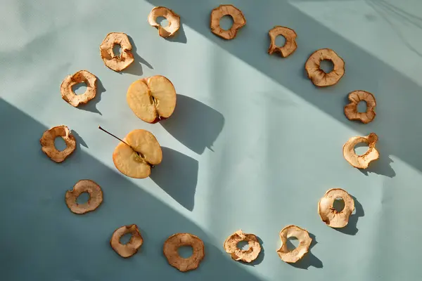 Сушеные нарезанные яблочные чипсы и свежие яблоки - здоровые альтернативные закуски в модных тенях. Правильная концепция питания. Вид сверху. Копирование пространства. — стоковое фото