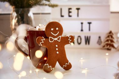 Noel sembolü, ev yapımı zencefilli kurabiye ve bulanık bokeh dekoru. Sıcak içecek ve marşmelovlu Noel süslemeleri. Estetik Noel atmosferi, ev konforu, sıcaklık konsepti