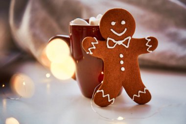 Noel sembolü, ev yapımı zencefilli kurabiye ve bulanık bokeh dekoru. Sıcak içecek ve marşmelovlu Noel süslemeleri. Estetik Noel atmosferi, ev konforu, sıcaklık konsepti