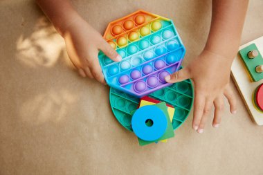 Bebekler renkli anti-stres oyuncaklarıyla oynarlar. Oyuncak hareketleriyle oynarlar. İt onu. Moda, motor becerilerin gelişmesi için bir oyuncak. Gökkuşağı duyusal kıpırdaması. Yeni moda silikon oyuncak ve ahşap eko oyuncaklar