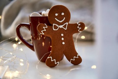 Noel sembolü, ev yapımı zencefilli kurabiye ve bulanık bokeh dekoru. Sıcak içecek ve marşmelovlu Noel süslemeleri. Estetik Noel atmosferi, ev konforu, sıcaklık konsepti