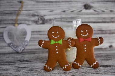 Noel Baba için zencefilli kurabiye ile süt. Antika ahşap masada el yapımı taze kurabiyeler ve sütlü bardaklar. Noel gelenekleri. Estetik atmosfer ve şenlikli Noel geçmişi. 