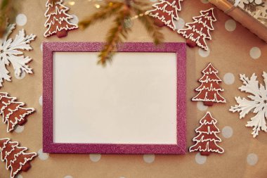 Pembe çerçeveli ev yapımı zencefilli kurabiye. Ev yapımı kurabiyeler. Bayramlık estetik kart. Noel atmosferi. Mutlu Noeller ve ev konforu. Yüksek kalite fotoğraf