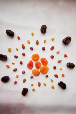 Güneşli, hurma, kurutulmuş kayısı, fındık, badem, şekerli meyve ve kuru üzüm şeklinde yaratıcı yiyecekler. Vegan doğal antioksidan yiyecekler, sağlıklı yiyecekler. Vejetaryen yemeği, sağlıklı beslenme konsepti