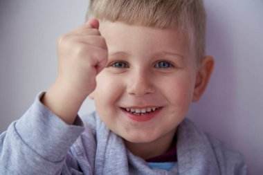 Sevimli gülümseyen çocuk kameranın önünde bir kamera gösteriyor. Yeni yürümeye başlayan çocuğun portresi. Yüksek kalite fotoğraf