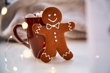 Noel sembolü, ev yapımı zencefilli kurabiye ve bulanık bokeh dekoru. Sıcak içecek ve marşmelovlu Noel süslemeleri. Estetik Noel atmosferi, ev konforu, sıcaklık konsepti