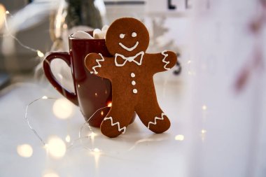 Noel sembolü, ev yapımı zencefilli kurabiye ve bulanık bokeh dekoru. Sıcak içecek ve marşmelovlu Noel süslemeleri. Estetik Noel atmosferi, ev konforu, sıcaklık konsepti