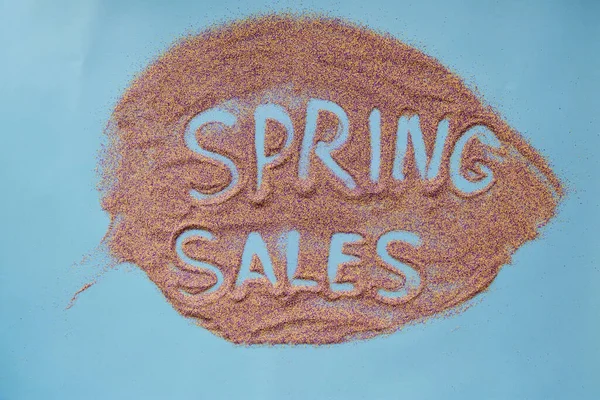 Bahar satışları el yazısıyla kumun üzerine yaprak şeklinde indirim konsepti yazdı. Renkli kum. Yaratıcı bahar satışları konsepti. Üst görünüm — Stok fotoğraf
