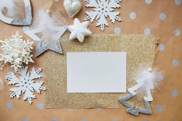 Weihnachtskarten-Attrappe. Papeteriekarte auf goldenem Hintergrund, Platz für Text. Trendige Dekorationen: flauschige Ornamente, weiße Schneeflocken. Ästhetisch festliche Atmosphäre. Blick von oben — Stockfoto