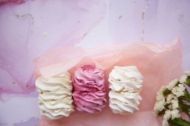 Kuru çiçeklerle süslenmiş yumuşak pembe ve beyaz marşmelov. Kadınsı kart konsepti. Sıcak kış hafta sonları. Ev yapımı tatlılar. Üst Manzara. Yüksek kalite fotoğraf