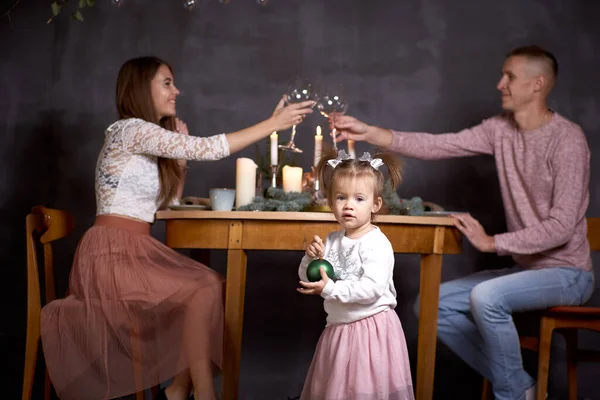 Lycklig familj med liten flicka i estetisk mysig heminredning bredvid bordet. Vacker ung familj. Bra humör och ha kul tillsammans. — Stockfoto