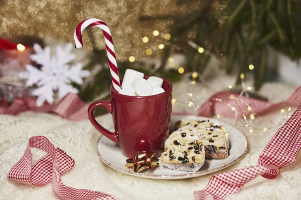 Hot drink in red cup with marshmallow and Christmas stollen - traditional holidays bread, gingerbread cookies, candy cone stick. Festive holidays Christmas background. Christmas food. Merry tradition. — Stock Photo, Image