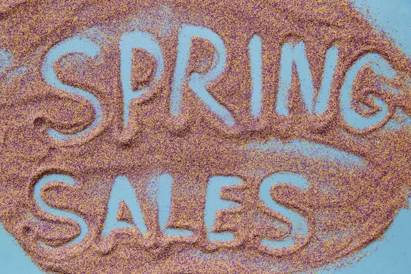 Spring sales hand written discount concept on sand. View from above. Colorful sand. Creative spring sales concept — стоковое фото