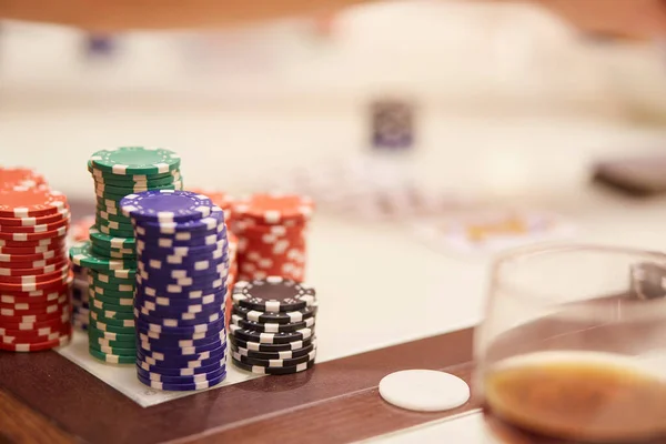 Masada fiş ve kartlarla poker oynama fikri. Bir bardak viski. Kumar konsepti. Uzayı kopyala Seçici odak.