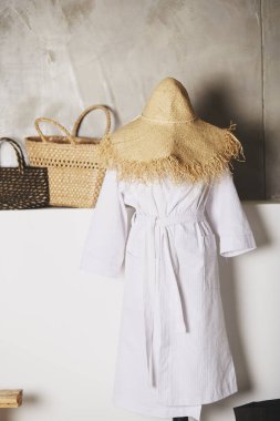 Bornoz ve hasır şapkalı manken. Arka planda hasır çöp torbaları var. Yüksek kalite fotoğraf