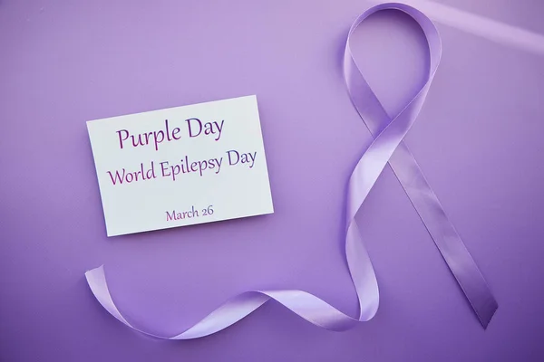 Mor Gün - Dünya Epilepsi Günü, 26 Mart. Epilepsi gününün sembolü. Kurdele ve metin.