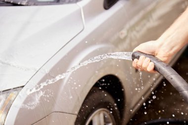 Arabayı hortumların altında suyla yıkamak. Ev rutinleri. Araç bakımı. Kapat..