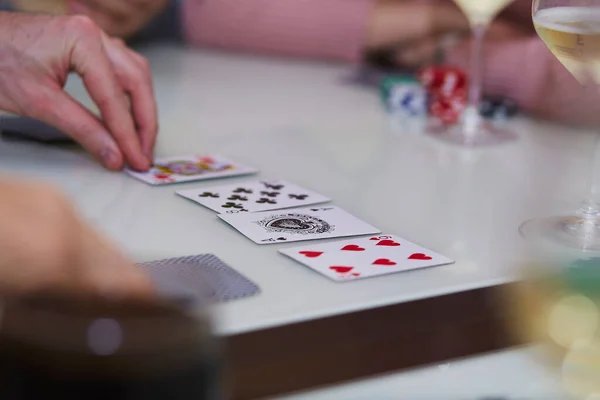 Mans consegna una partita di poker. Patatine, carte, bicchiere di champagne sul tavolo con riflesso. Fotografia stile di vita. Club di poker — Foto Stock