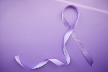 Eflatun Gün için mor kurdele - Dünya Epilepsi Günü, 26 Mart. Eflatun arkaplanlı gölgeli Epilepsi Gününün sembolü.