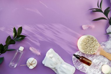 SPA güzellik tedavisi tam hijyen aksesuarları, doğal sabun, esans yağı, masaj fırçası, banyo bombası, mor arka planda süngerler. Gölgeler, boşluğu kopyala.