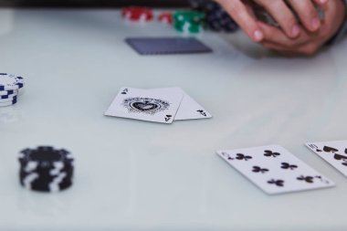 Adamın elleri kartları karıştırıyor. Bir poker oyununda masada iki as, masada da fişler. Anın tadını çıkarıyorum, arkadaşlarla dijital detoks. Yaşam tarzı fotoğrafçılığı. Samimi bir an. Seçici odak