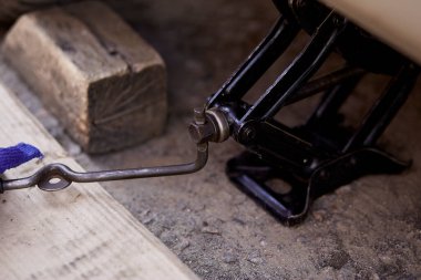 Lastik değiştirmek için arabayı vidayla kaldırmak. Yaşam tarzı fotoğrafçılığı. 