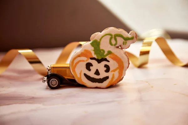 Halloween dekorer med orange pumpa mugg, handgjord kaka, filtade pumpor och gul retrobil. Glad Halloween festligt koncept. — Stockfoto